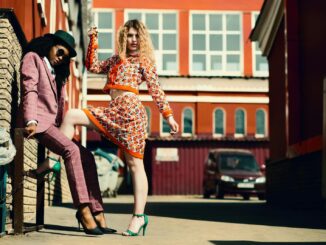 Stylish women posing in an urban alley showcasing contemporary fashion trends.