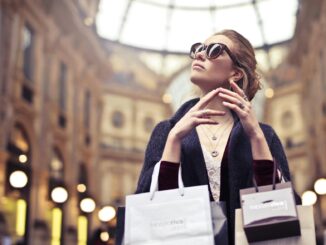 Elegant woman wearing sunglasses shopping in Milan's iconic Galleria Vittorio Emanuele II.